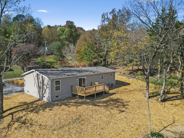 back of property with a yard and a wooden deck