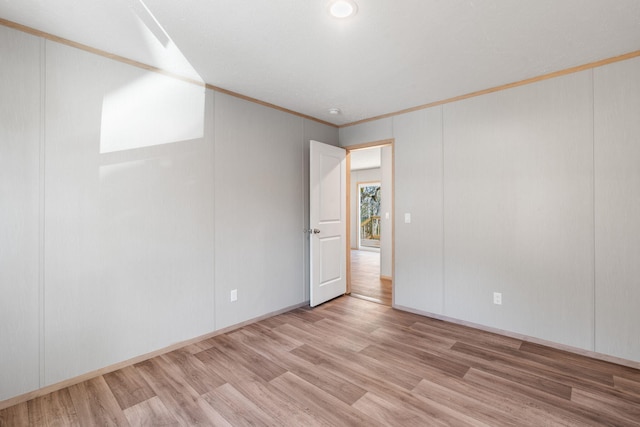 unfurnished room featuring light hardwood / wood-style flooring and ornamental molding