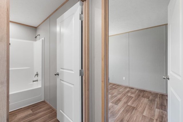 bathroom featuring shower / bath combination, wood-type flooring, and crown molding