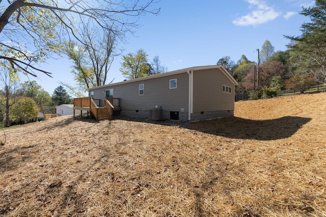 back of house featuring a wooden deck and central AC