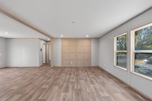 interior space with a textured ceiling and light hardwood / wood-style flooring