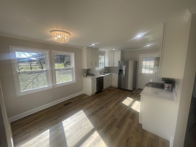 kitchen with crown molding, dishwasher, stainless steel fridge, white cabinetry, and a sink