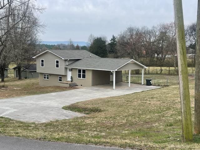 view of front of property with an attached carport, concrete driveway, a front lawn, and roof with shingles