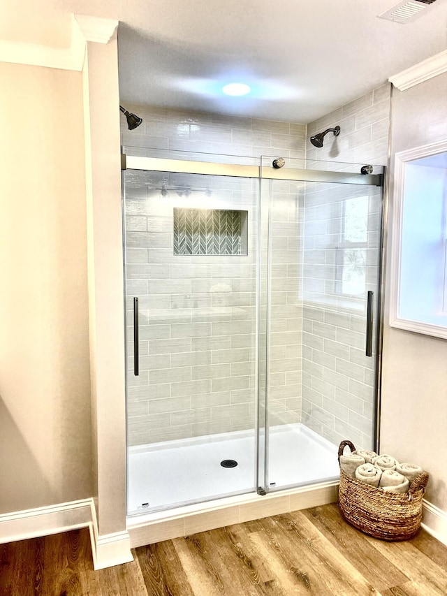 full bath featuring visible vents, a shower stall, baseboards, and wood finished floors