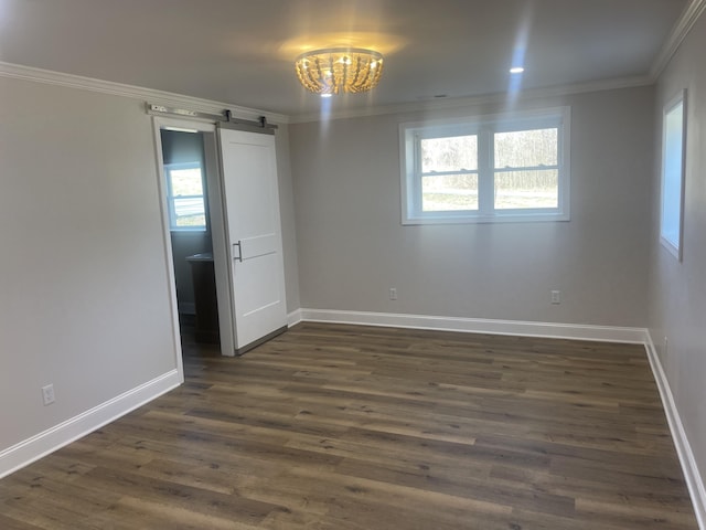 empty room with a barn door, baseboards, dark wood-style flooring, and ornamental molding