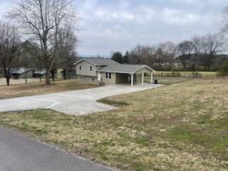 view of yard with a carport and driveway