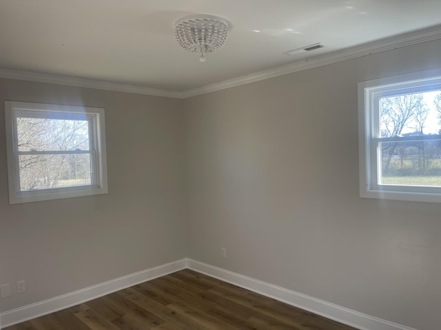 empty room featuring visible vents, crown molding, dark wood-type flooring, and baseboards