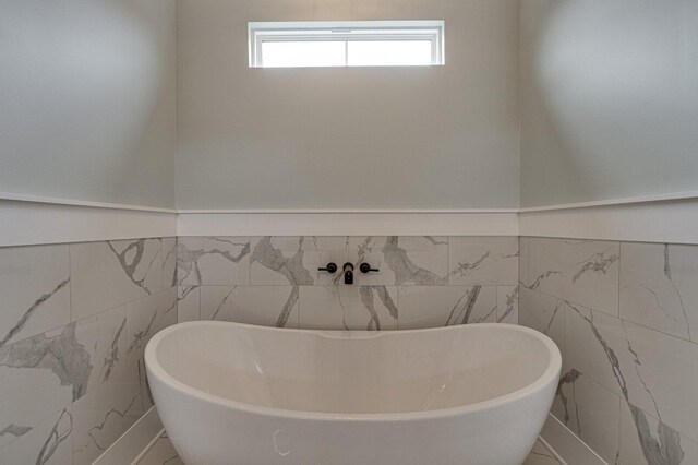 bathroom with tile walls and a tub