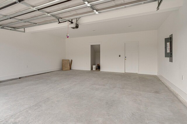 garage with a garage door opener and electric panel