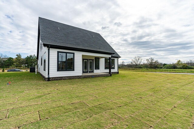 rear view of property with a lawn and central AC