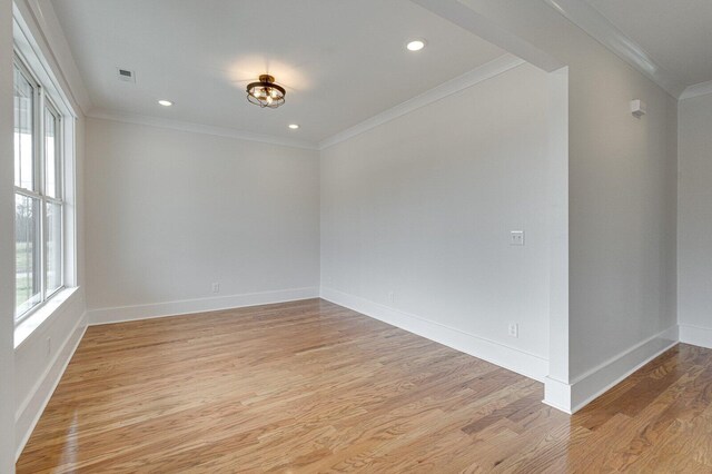 spare room featuring light hardwood / wood-style flooring and ornamental molding