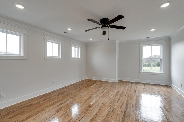 unfurnished room featuring plenty of natural light, ceiling fan, light wood-type flooring, and ornamental molding