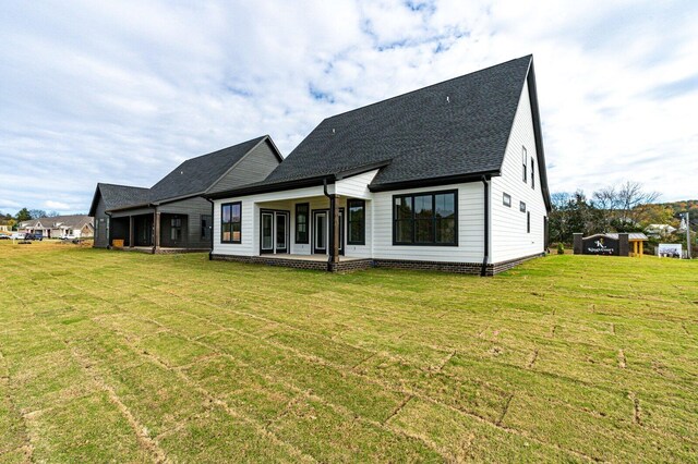 rear view of property featuring a lawn