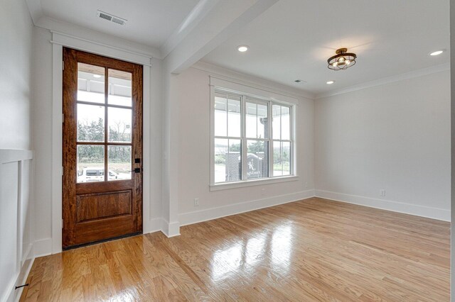 entryway with light wood-type flooring and ornamental molding