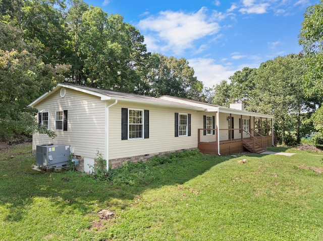 ranch-style home featuring a porch, a front lawn, and central AC unit