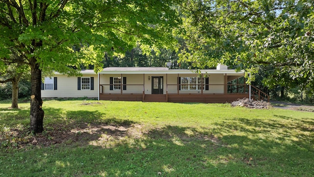 ranch-style house featuring covered porch and a front yard