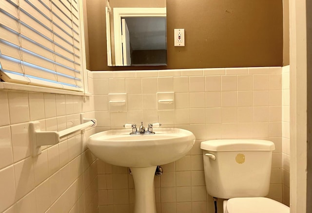 bathroom featuring tile walls and toilet