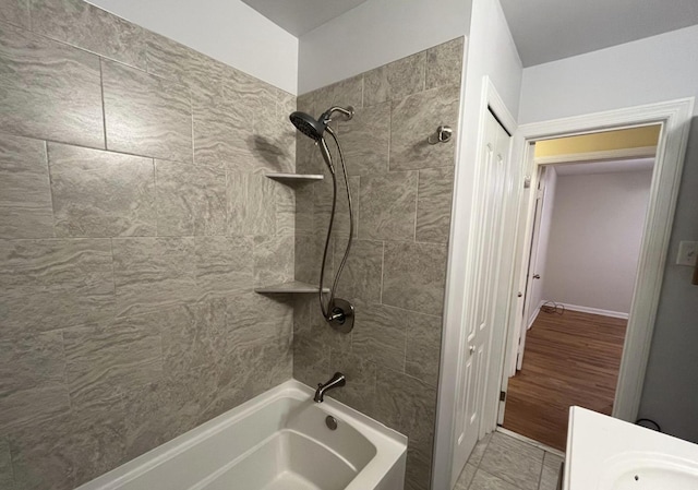 bathroom featuring tile patterned flooring and tiled shower / bath