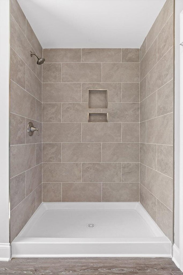 bathroom featuring tiled shower and hardwood / wood-style floors