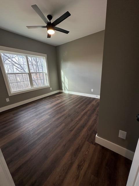 spare room featuring ceiling fan and dark wood-type flooring