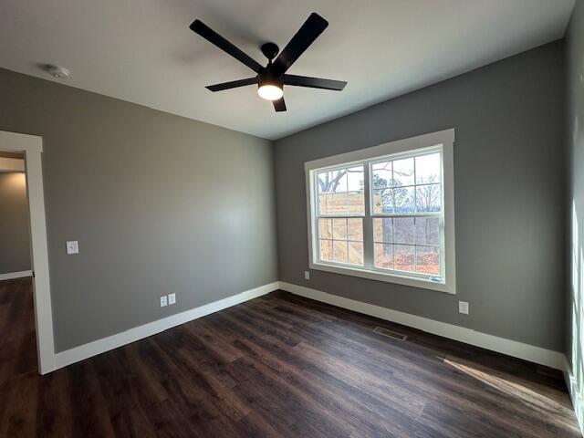 unfurnished room featuring ceiling fan and dark hardwood / wood-style floors