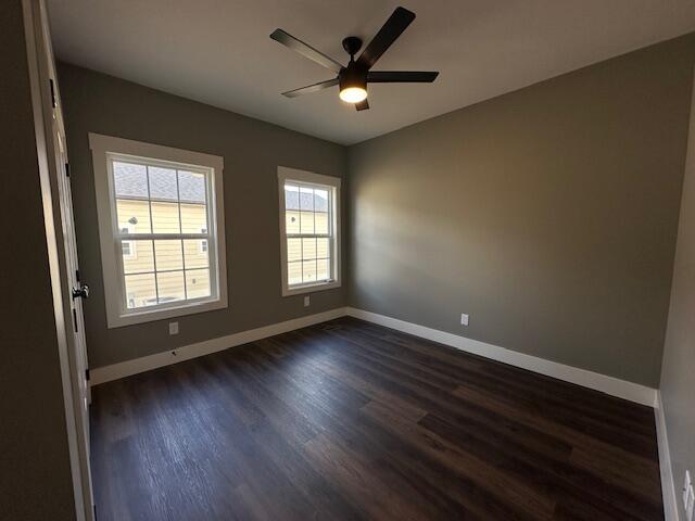 spare room featuring dark hardwood / wood-style floors and ceiling fan