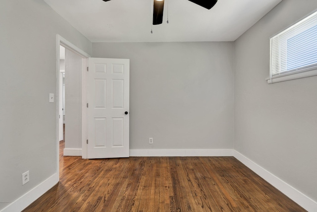 spare room with ceiling fan and dark wood-type flooring