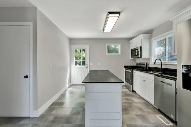 kitchen featuring a wealth of natural light, sink, white cabinets, and appliances with stainless steel finishes