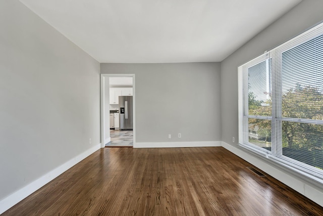 unfurnished room with dark wood-type flooring