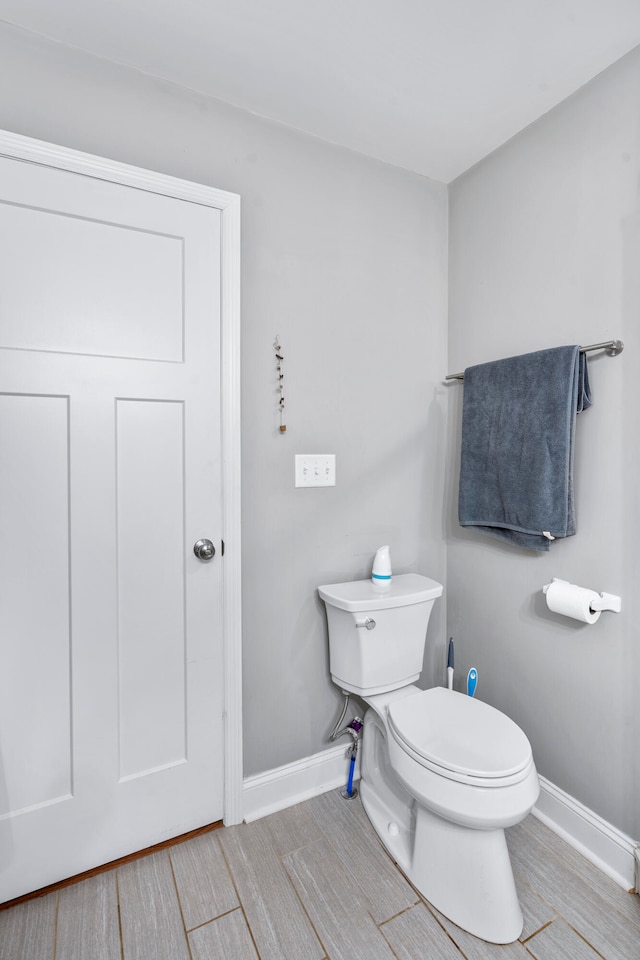 bathroom with toilet and wood-type flooring