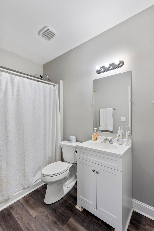 bathroom with a shower with curtain, hardwood / wood-style floors, vanity, and toilet