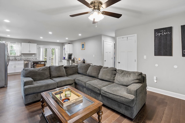 living room with ceiling fan, dark hardwood / wood-style flooring, and sink