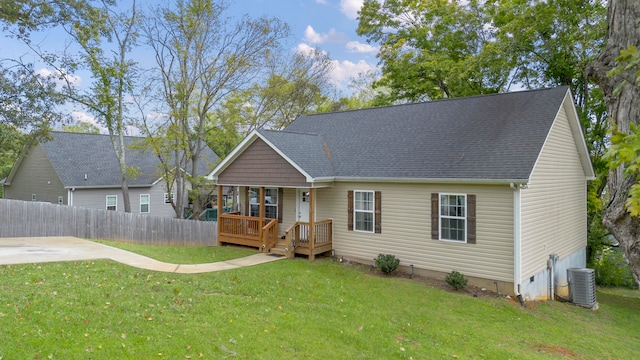 rear view of house with cooling unit and a yard