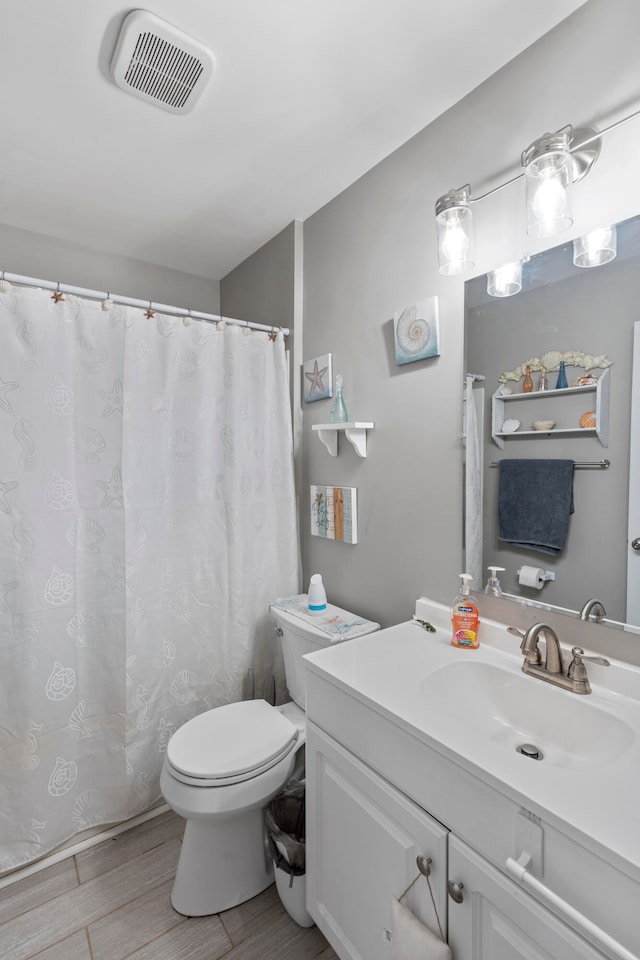 bathroom with vanity, wood-type flooring, and toilet