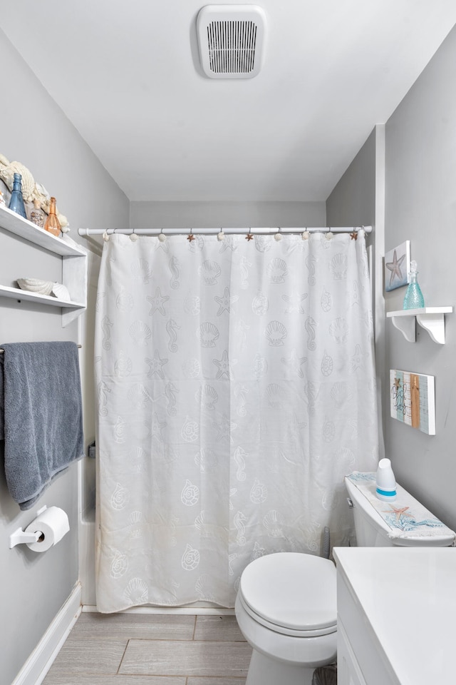 full bathroom featuring shower / bath combo, vanity, hardwood / wood-style flooring, and toilet