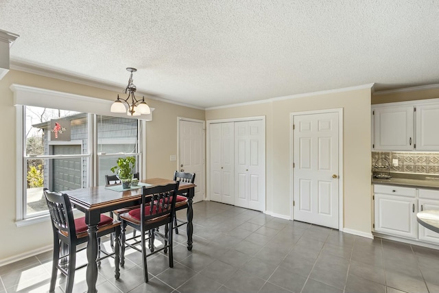 dining area with baseboards, dark tile patterned flooring, and crown molding