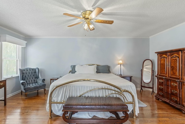 bedroom with baseboards, ornamental molding, and wood finished floors