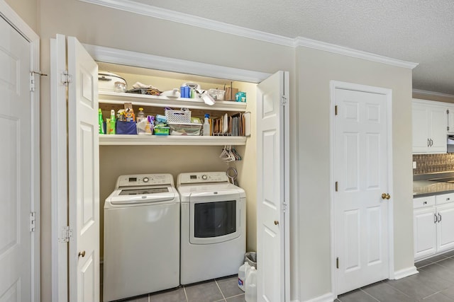 washroom with crown molding, dark tile patterned floors, separate washer and dryer, a textured ceiling, and laundry area