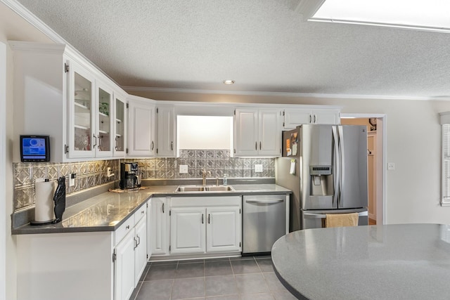 kitchen featuring white cabinets, tasteful backsplash, a sink, and stainless steel appliances
