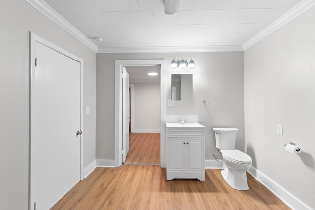 bathroom featuring hardwood / wood-style flooring, toilet, vanity, and ornamental molding