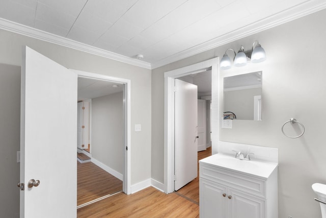 bathroom with vanity, toilet, ornamental molding, and hardwood / wood-style floors