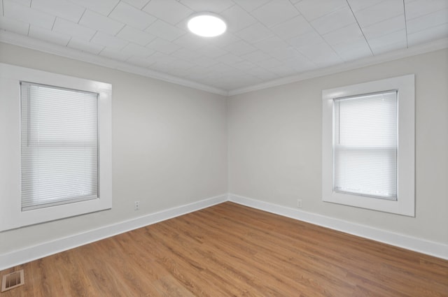 spare room featuring hardwood / wood-style flooring and crown molding