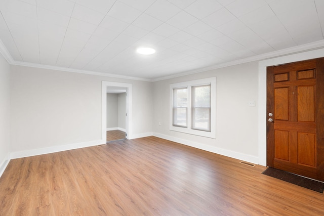 empty room featuring crown molding and light wood-type flooring