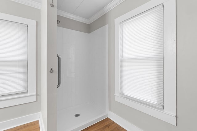 bathroom with a shower, plenty of natural light, hardwood / wood-style floors, and crown molding