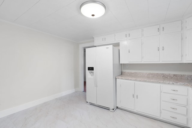 kitchen with crown molding, white fridge with ice dispenser, and white cabinetry