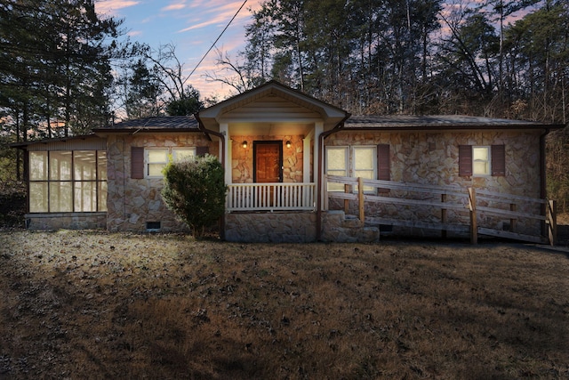 view of front of property featuring a sunroom and a lawn