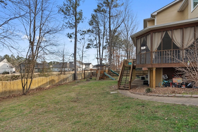 view of yard featuring a sunroom and a playground