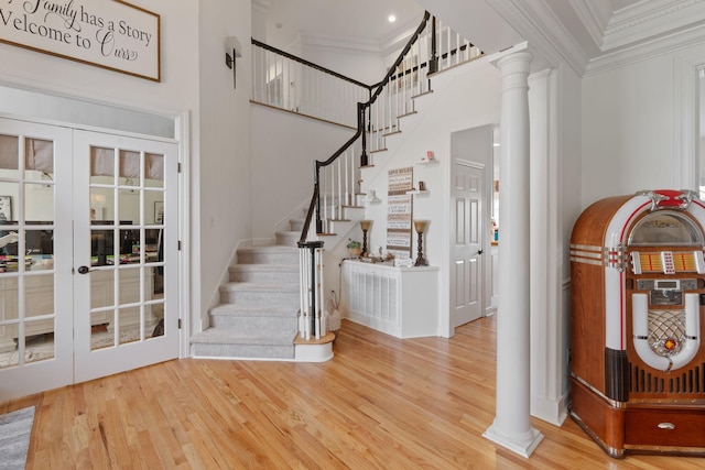 entryway with hardwood / wood-style flooring, ornamental molding, french doors, and ornate columns