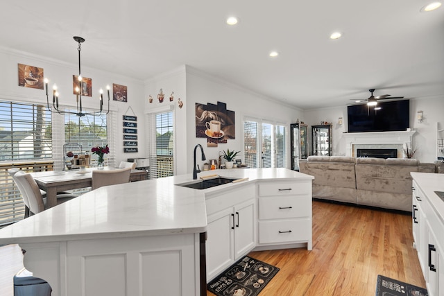 kitchen with an island with sink, sink, and white cabinets