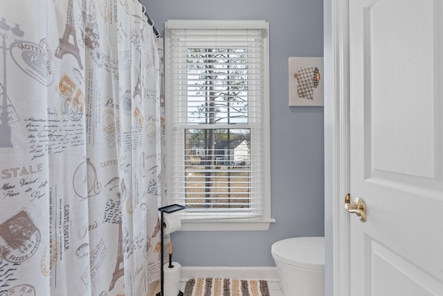 bathroom featuring plenty of natural light, tile patterned floors, and toilet